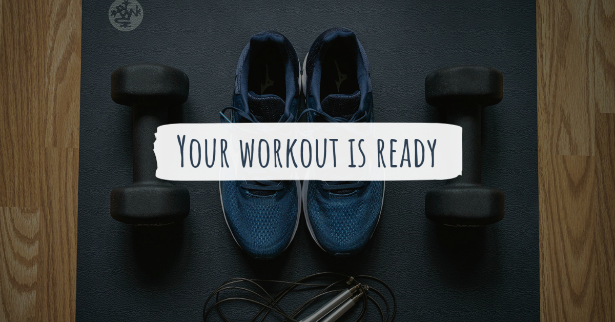 Shoes and dumbbells on a mat with text 'Your Workout Is Ready'